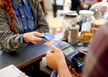 Shot of a customer paying for their order with a credit card machine in a cafe